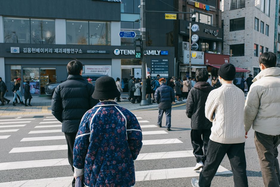 people crossing a busy crosswalk in Seoul