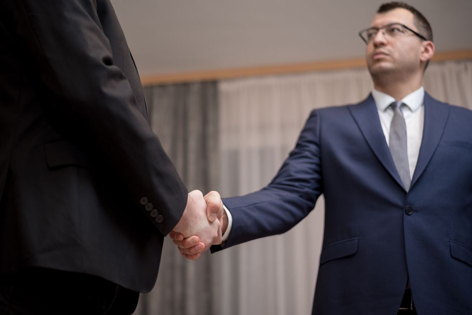 two professionals shaking hands in an office