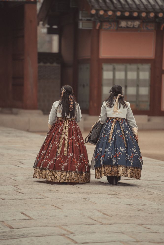 Women wearing traditional hanbok walking through a traditional Seoul neighborhood during Chuseok