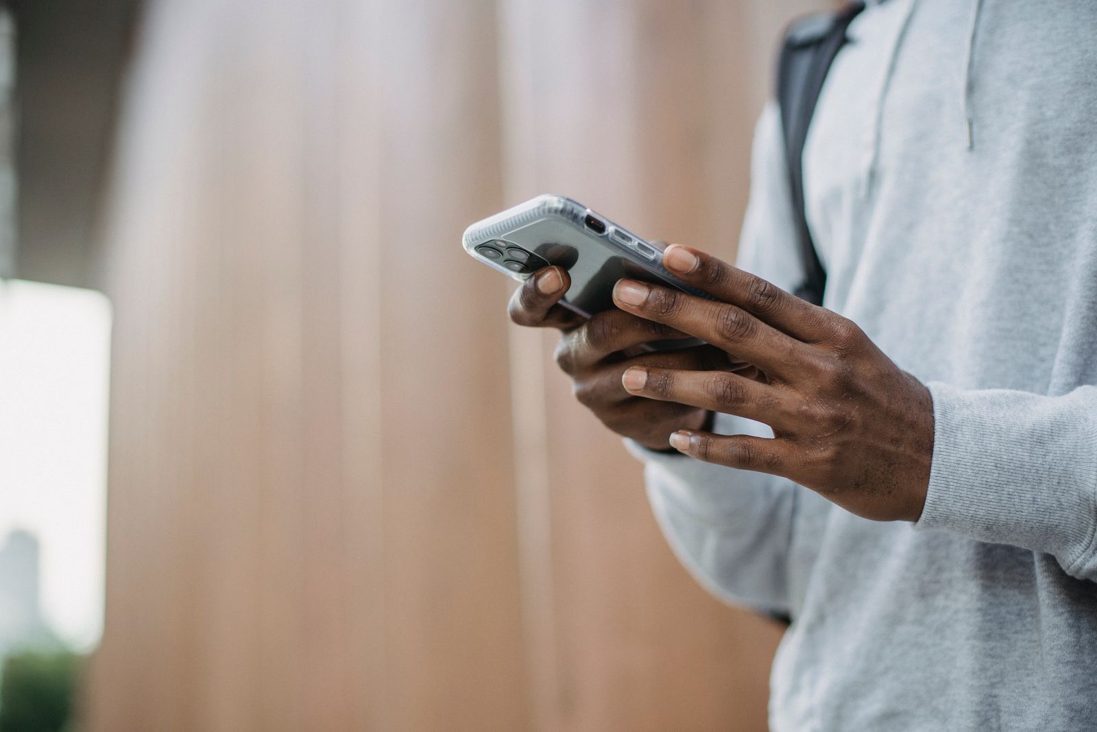 Man checking his smartphone outdoors in daylight