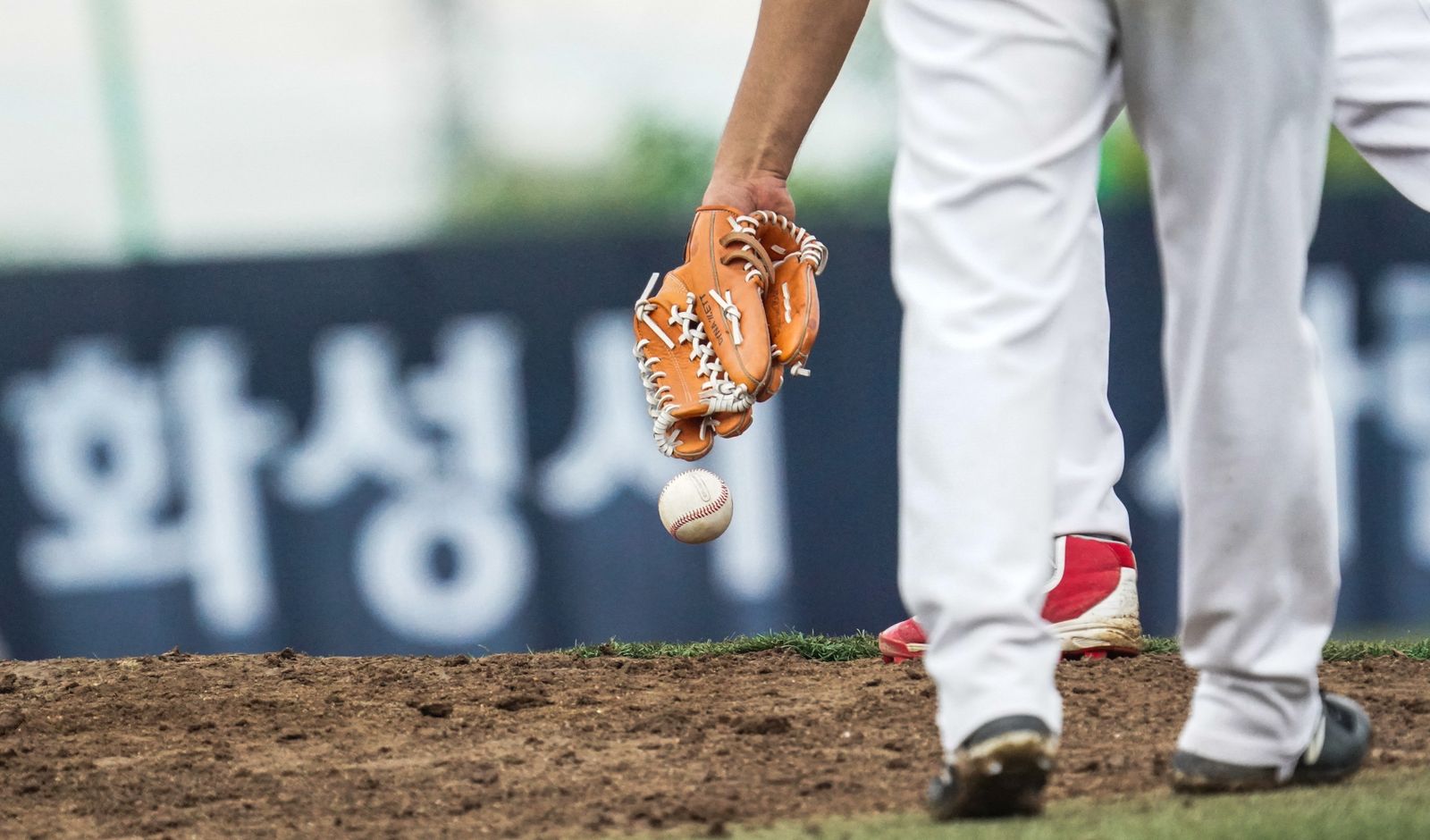 close-up of a baseball glove and ball on the pitcher's mound at a Korean baseball field