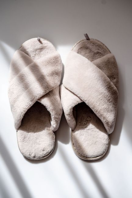 A pair of soft indoor slippers used indoors in place of outdoor shoes