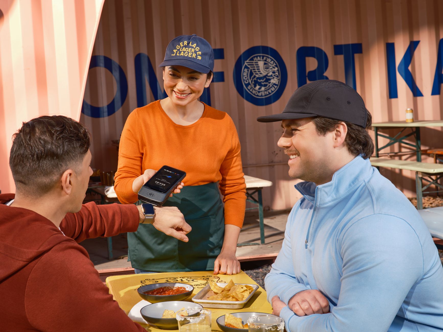 Vendor accepting a phone tap payment at an outdoor food stall