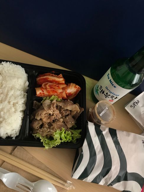 Korean delivery food packed in a takeout tray with rice, kimchi, and grilled meat