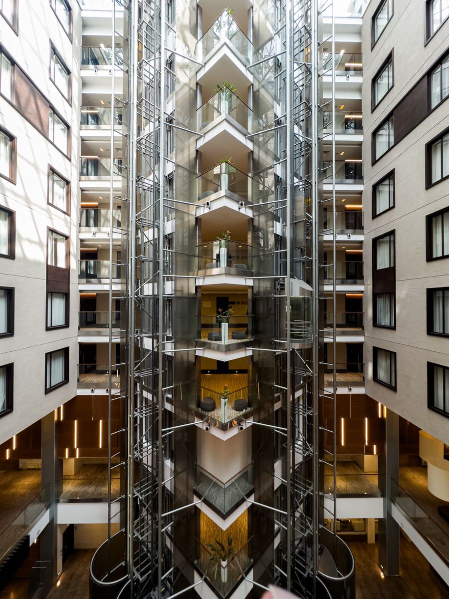 Modern high-rise apartment lobby with glass elevators and balconies in Korea