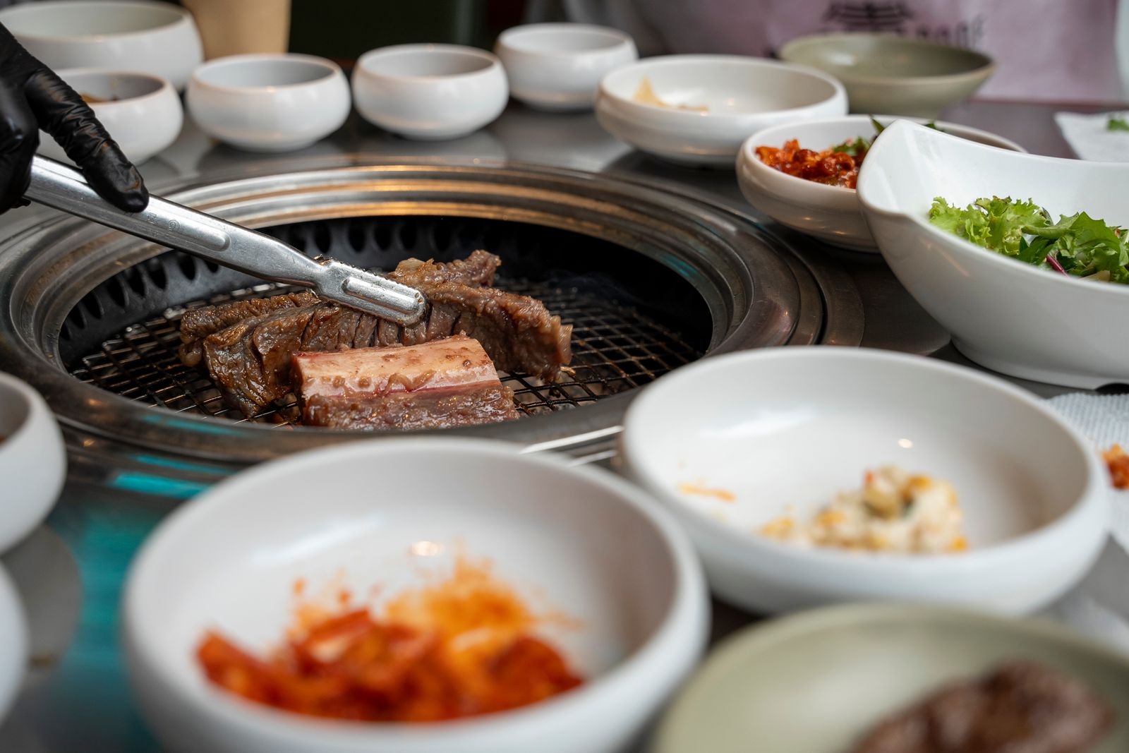 Korean barbecue grilling on a tabletop with assorted side dishes at a group dinner