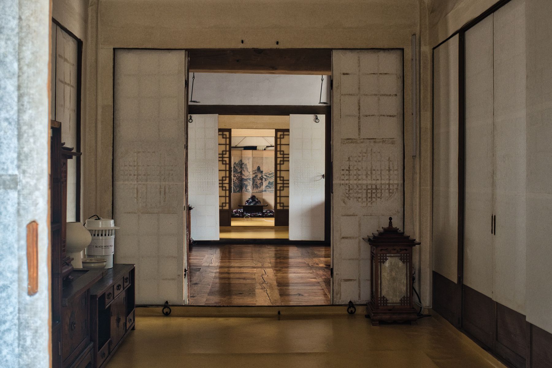 Interior view of a traditional Korean hanok home with wooden floors and sliding paper doors