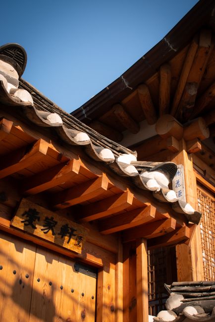 Close-up of a traditional Korean hanok building with a tiled roof and wooden beams