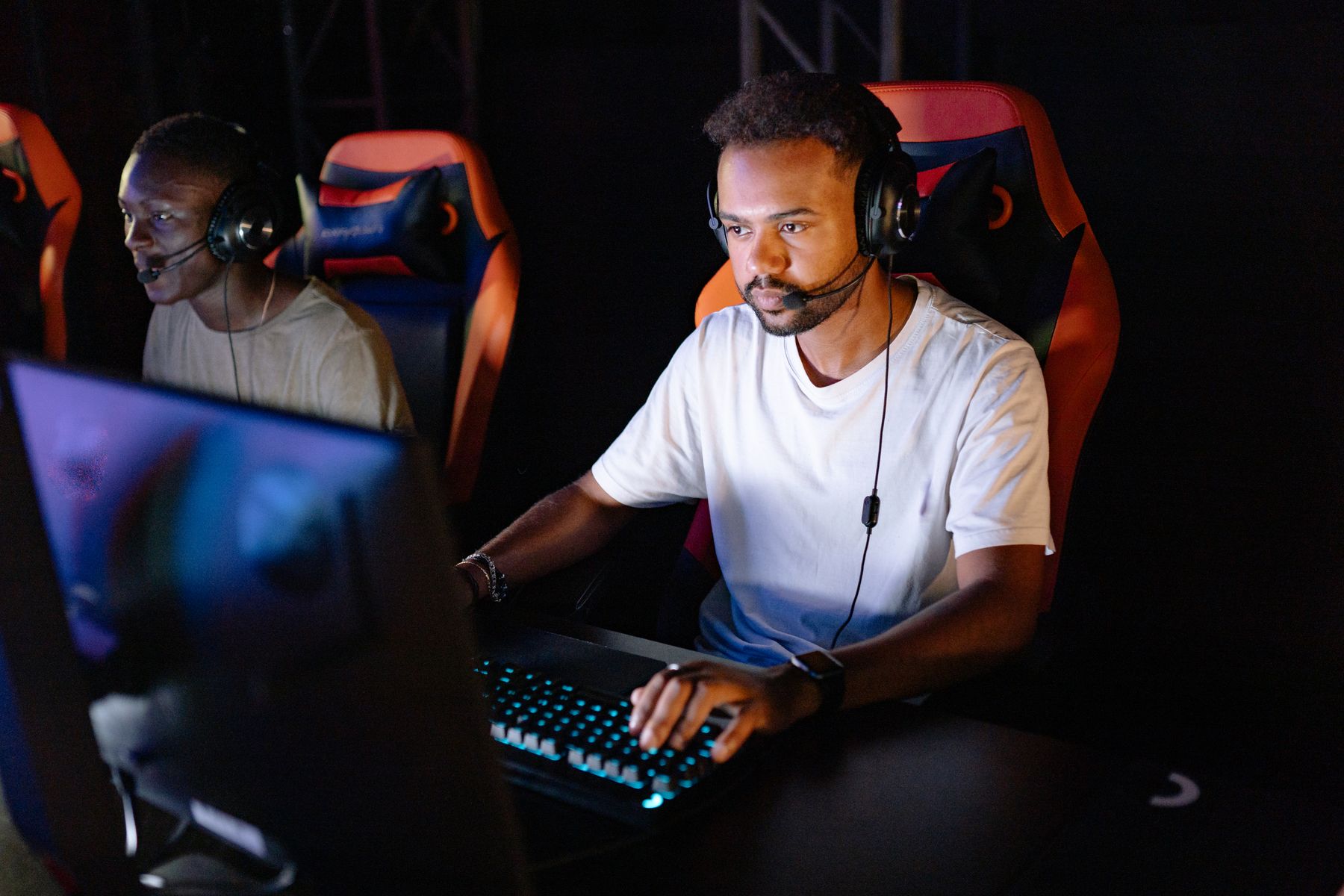 Two gamers wearing headsets deep in an intense late-night gaming session