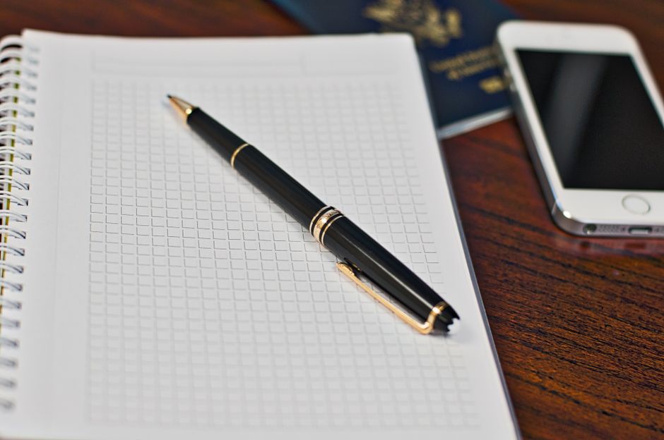 Passport and notebook on a desk, representing paperwork and official documents