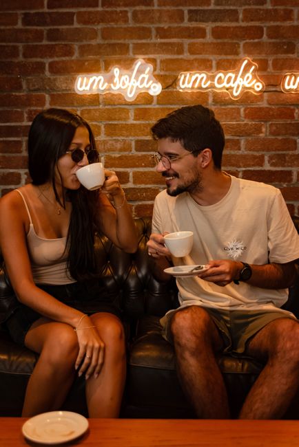 Two people talking over coffee at a small cafe table
