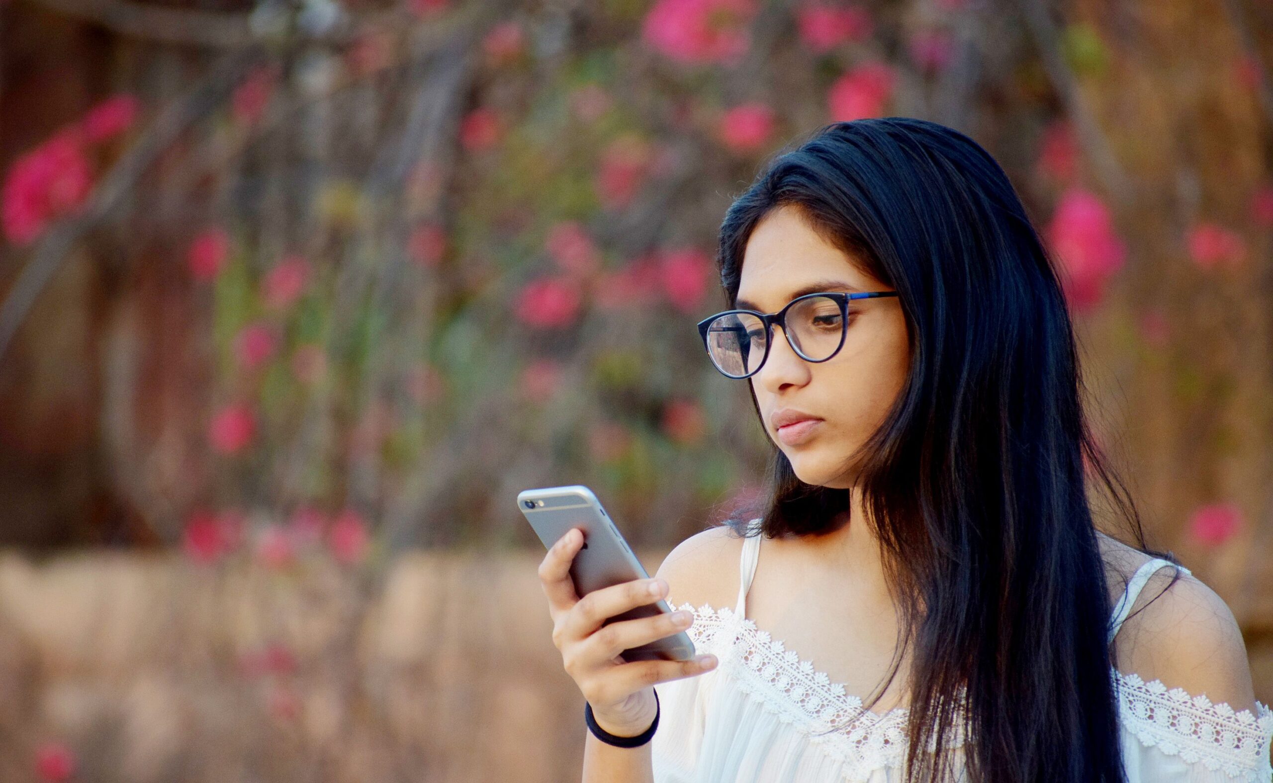 Young woman smiling while texting on her smartphone