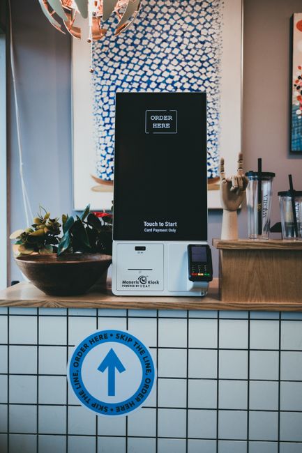 A modern self-order kiosk setup in a restaurant interior
