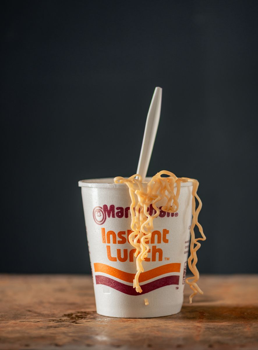 A cup of instant noodles with chopsticks resting on top