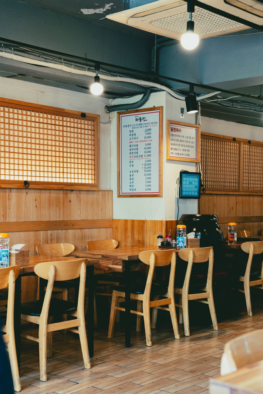 Interior of a traditional Korean restaurant with wooden tables and low seating near the entrance