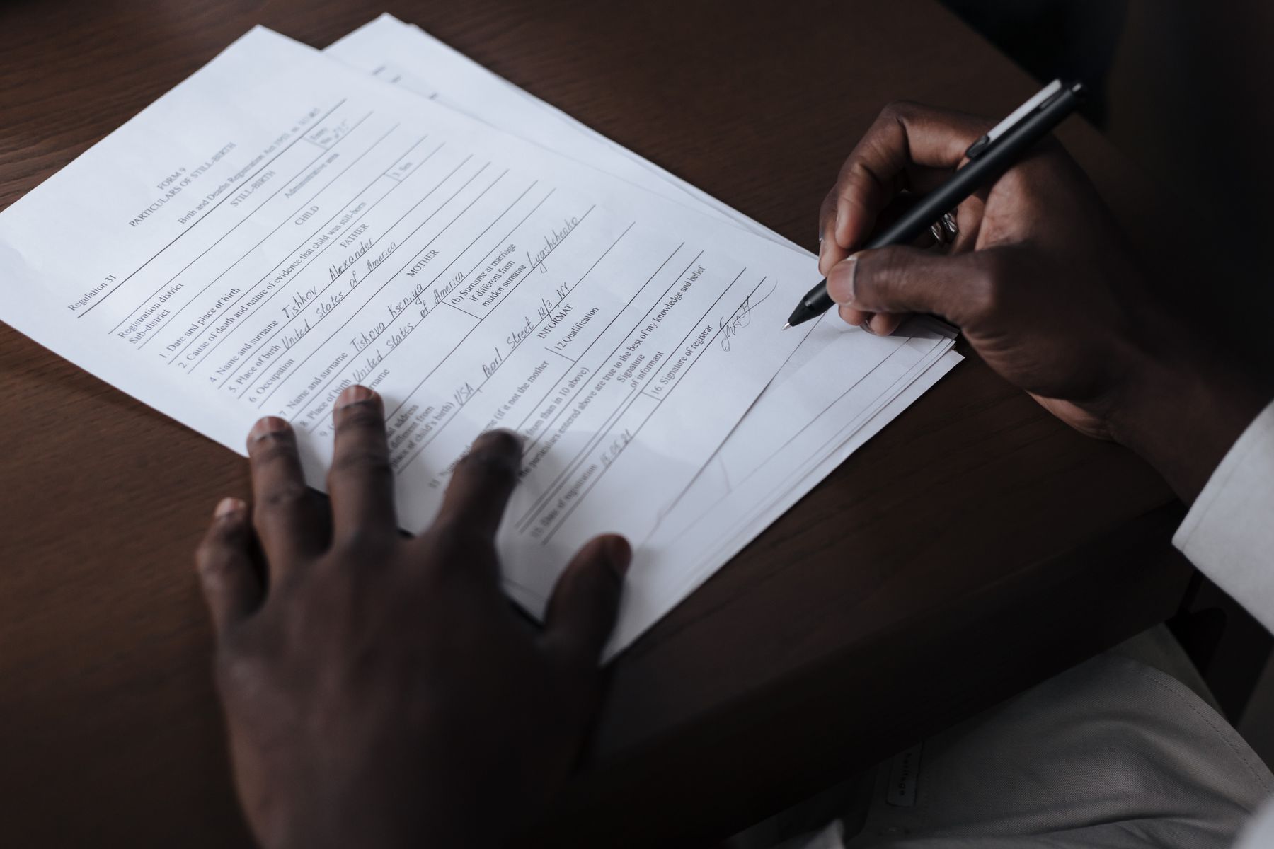 Person signing official paperwork, the kind of form where first name and last name boxes confuse Korean name order