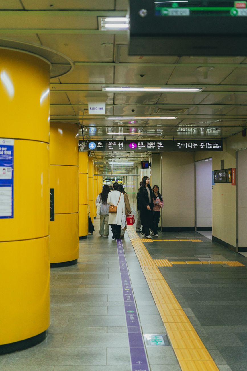 Commuters walking through a Seoul metro station platform