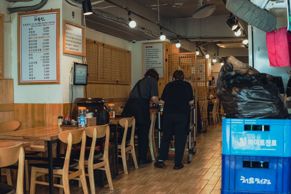 Staff organizing tables inside a traditional Korean restaurant in Seoul
